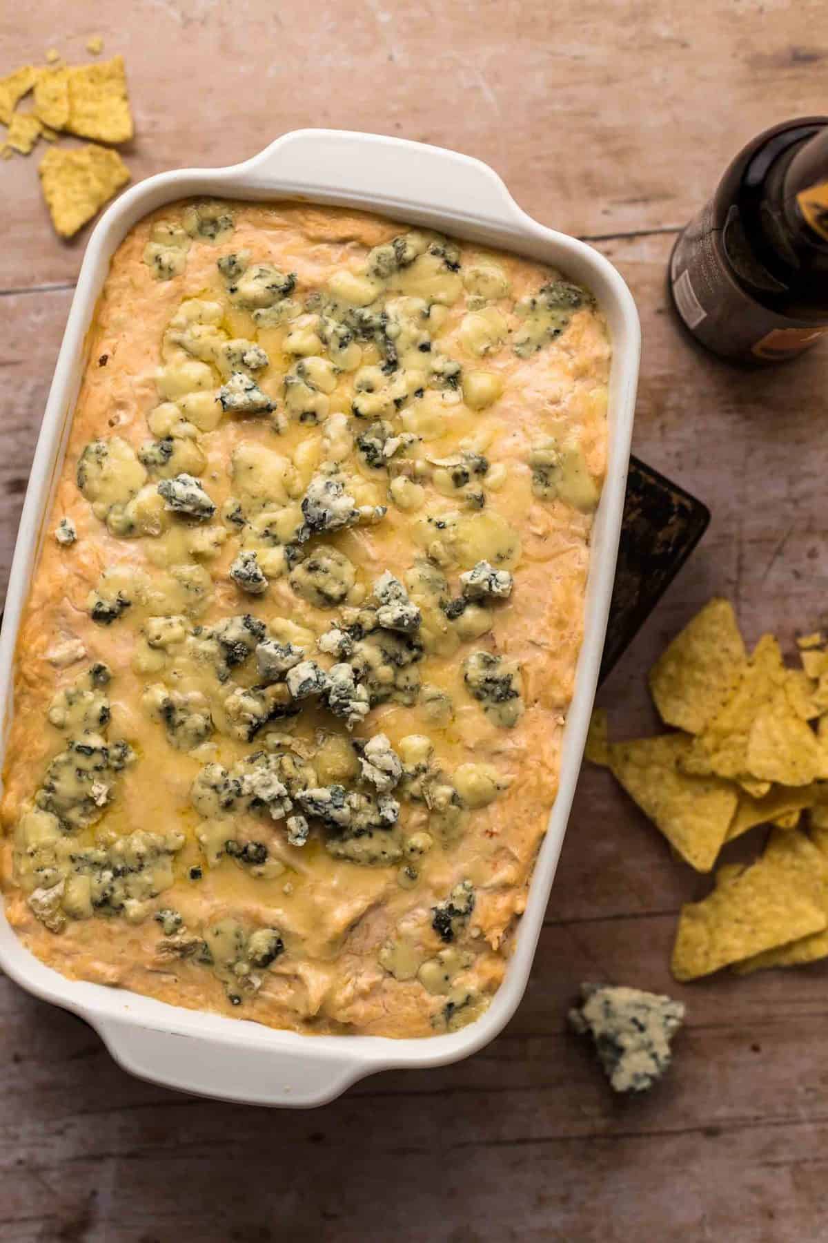 Beer Cheese Buffalo Chicken Dip is a fun and flavorful twist on a classic party recipe! This buffalo chicken dip with blue cheese and beer is just perfect for tailgating. Nothing goes better together than wings and beer (and cheese)! Baked Beer Cheese Buffalo Chicken Dip