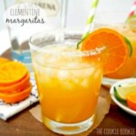 clementine margaritas with orange slices and a straw.