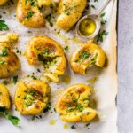smashed potatoes on a baking sheet with parchment paper