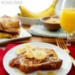 a plate of french toast with bananas and syrup.