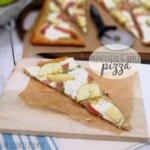 a slice of apple and goat cheese pizza on a cutting board.