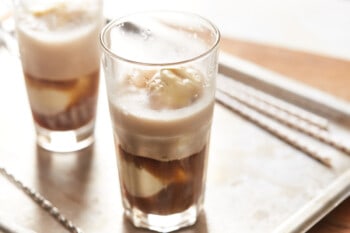 root beer poured over vanilla ice cream in clear glasses.