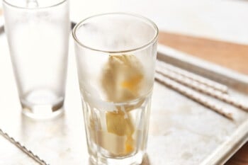 2 scoops of vanilla ice cream added to a clear glass.