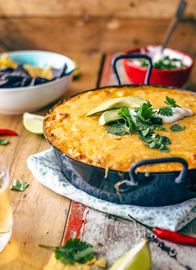 Chicken Enchilada Dip in large dish, next to a bowl of tortilla chips