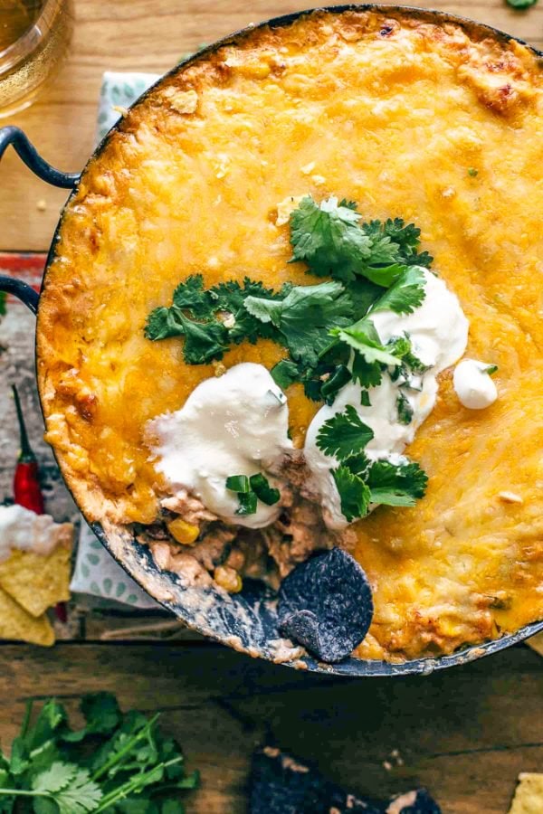Cheesy chicken enchilada dip topped with sour cream and cilantro.