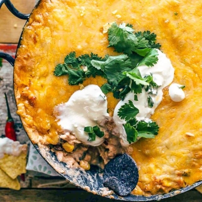 Chicken Enchilada Dip is one of the cheesiest and most delicious dips I've ever made. This easy Tex Mex dip recipe is filled with chicken, cream cheese, corn, beans, tomatoes, and enchilada sauce. It's sure to be an instant favorite on game day, or at any get-together!