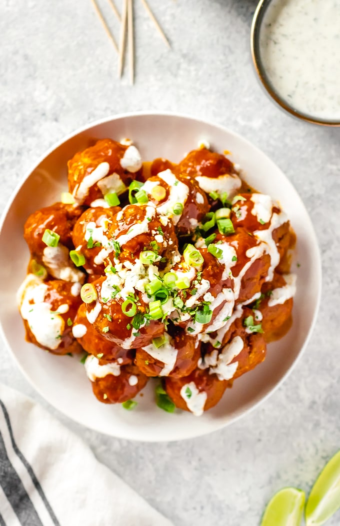 overhead picture of buffalo chicken meatballs garnished with ranch and scallions