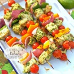 a plate of skewers with tomatoes and vegetables on it.