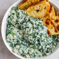 Crockpot Spinach Dip is a delicious and healthy(er) way to enjoy spinach parmesan dip at your next tailgate party. This easy spinach dip is the perfect appetizer! It's so tasty AND it's a healthy spinach dip you won't feel guilty about eating!