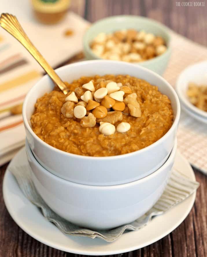 Pumpkin Pie Oatmeal is a healthy and delicious breakfast for fall. Delightfully warm and cozy, you'll look forward to it every morning! Two bowls stacked on plate showing Pumpkin Oatmeal with butterscotch chips and walnuts.