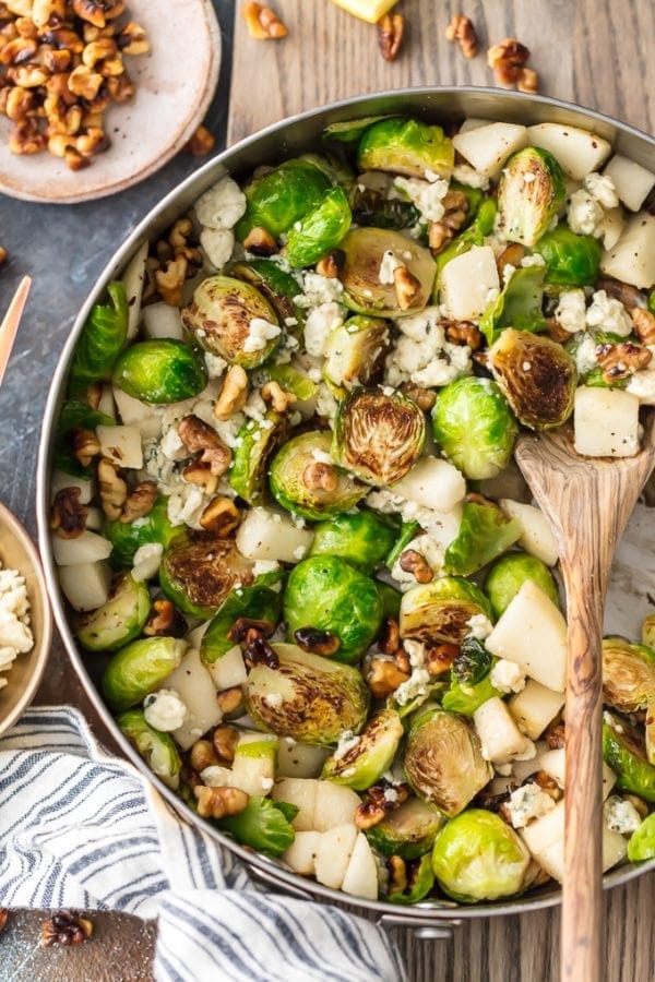 sautéed Brussels sprouts in a skillet pan, with walnuts, sliced pears, and blue cheese crumbles