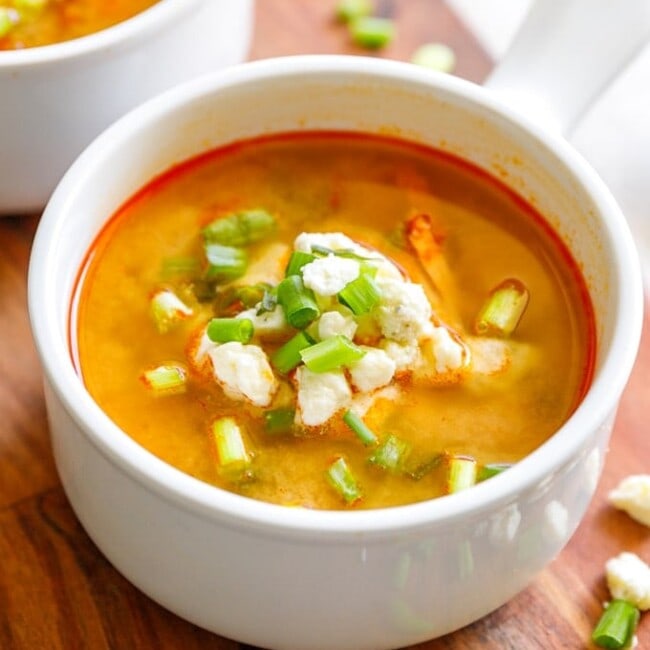 Buffalo Chicken Soup with green onions and cheese in a small bowl