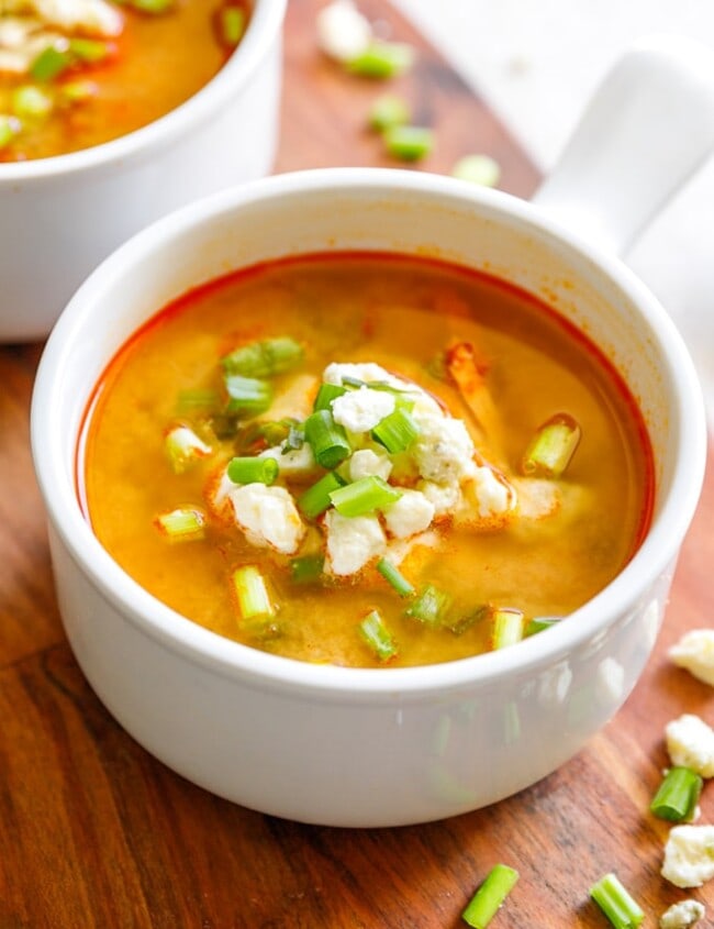 Buffalo Chicken Soup with green onions and cheese in a small bowl