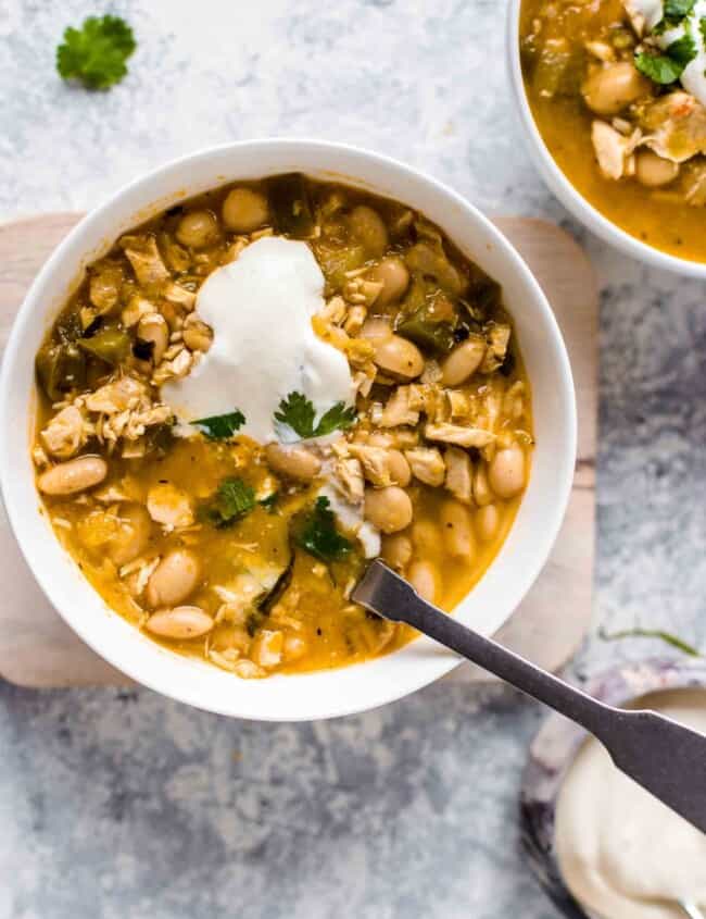 White Bean Chicken Chili is a super easy and deliciously spicy recipe. This EASY chicken chili recipe is perfect for those colder months, and it's so full of flavor. This spicy chili recipe is sure to warm you right up! You definitely need to make up a batch of this easy white chicken chili ASAP!