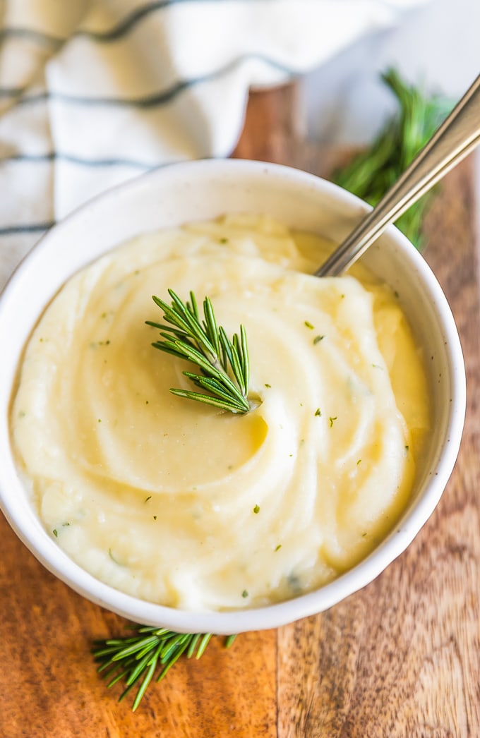 Garlic Mashed Cauliflower Recipe with Rosemary may be healthier, but tastes just as good as Mashed Potatoes! This Mashed Cauliflower is perfect for Thanksgiving, Christmas, Easter, or any day of the year. You won't regret making this Garlic Mashed Cauliflower Recipe; missing out on calories and gaining all the flavor! This healthy side dish will be your new favorite recipe.