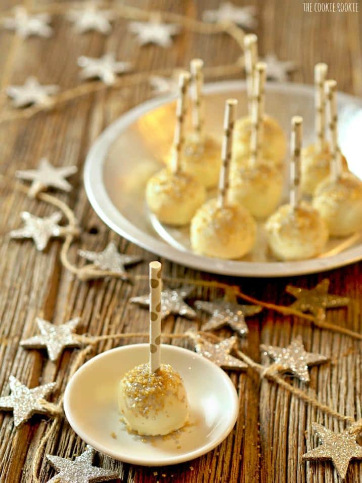 cake pop on a small plate with several cake pops behind it