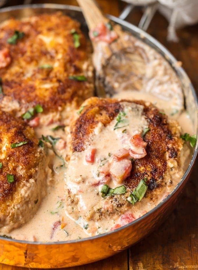 This Basil Chicken recipe with cream sauce has always been one of my favorite recipes. This dish has a creamy tomato basil sauce made with buttermilk and cheese that is just to die for! Easy breaded chicken, tomatoes, fresh herbs, and more make up this fool-proof skillet chicken recipe. basil chicken in a skillet