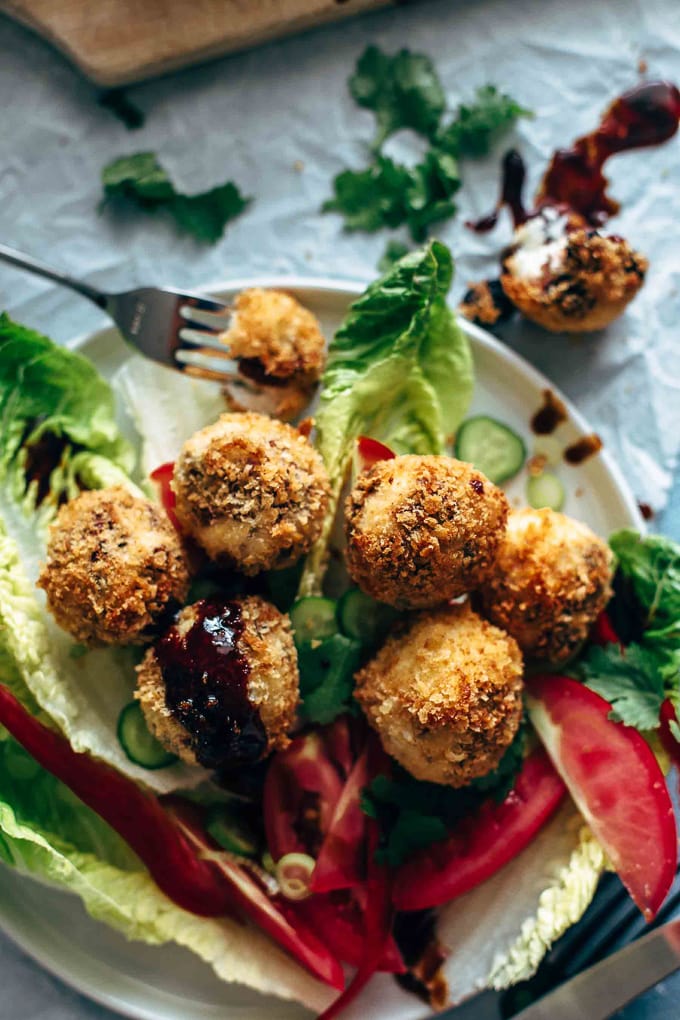 A plate of greens topped with fried goat cheese balls