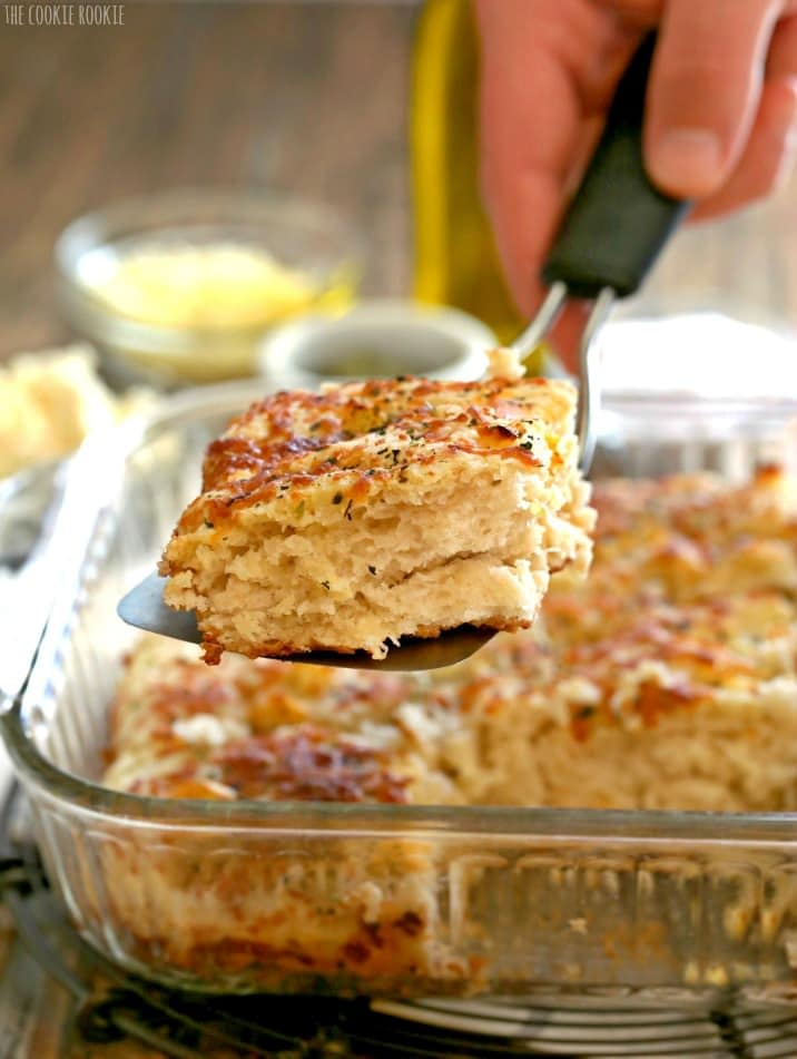 spatula taking a piece of focaccia bread out of a baking dish