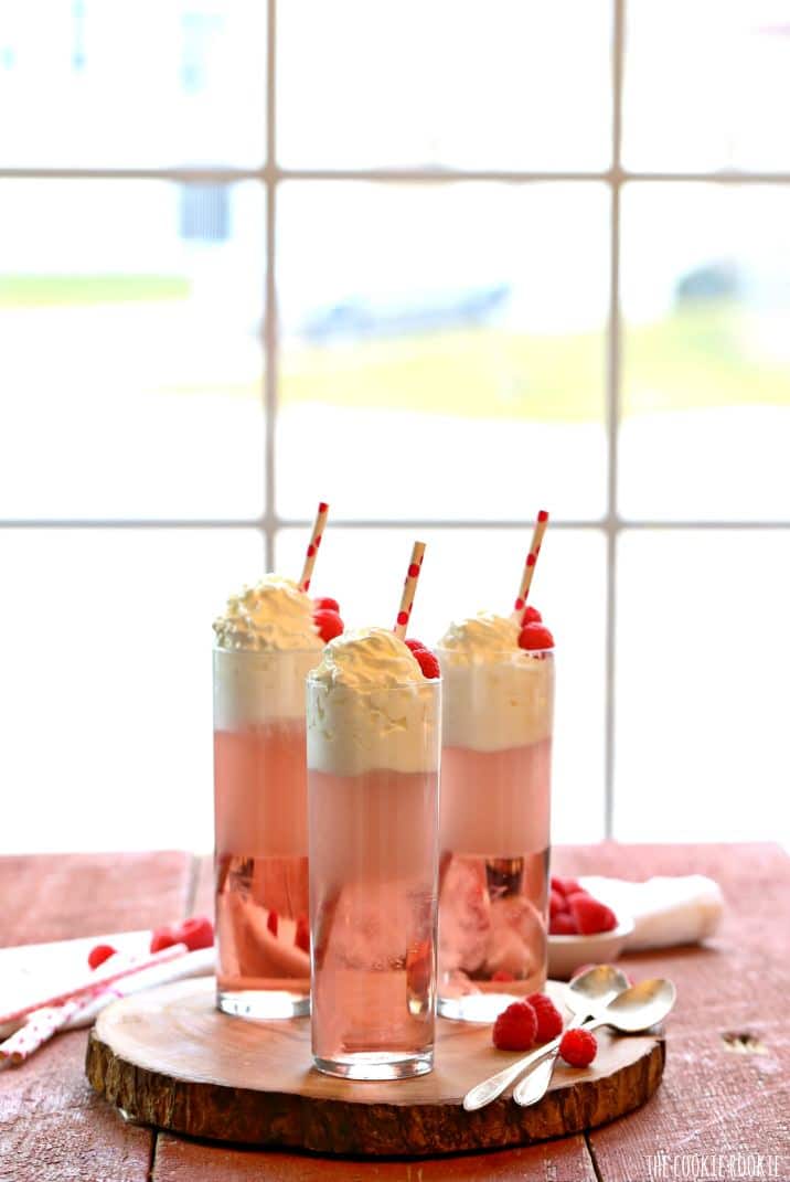 three pink coktails in front of a window
