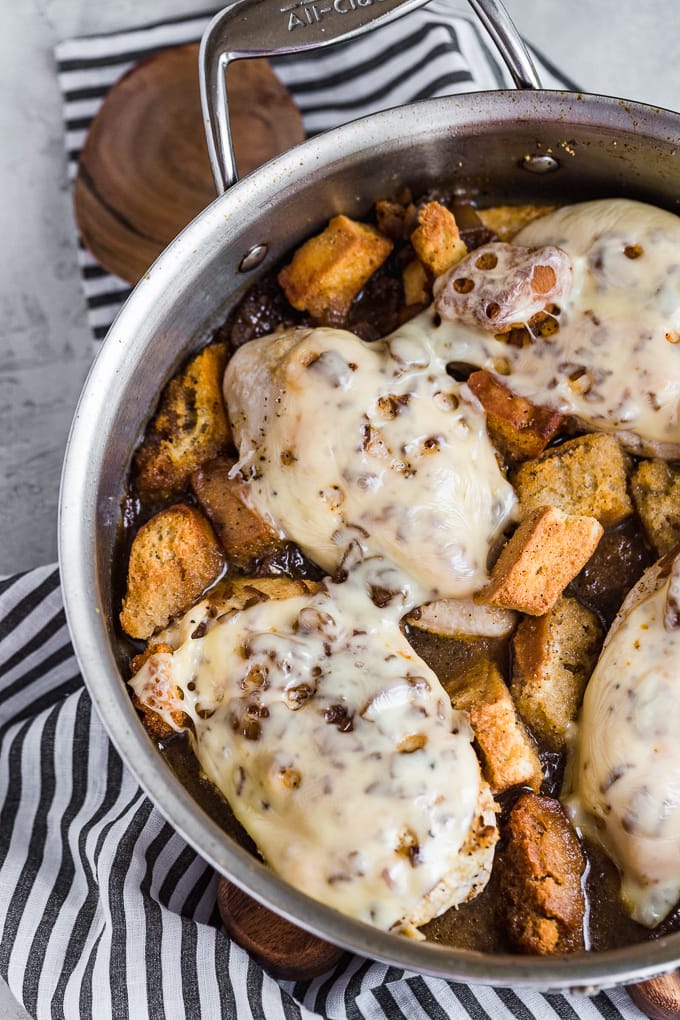 Chicken, french onion soup, and croutons in a skillet