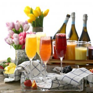 several homemade bellinis in champagne glasses