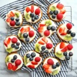 a stack of fruit topped cookies on a cooling rack.
