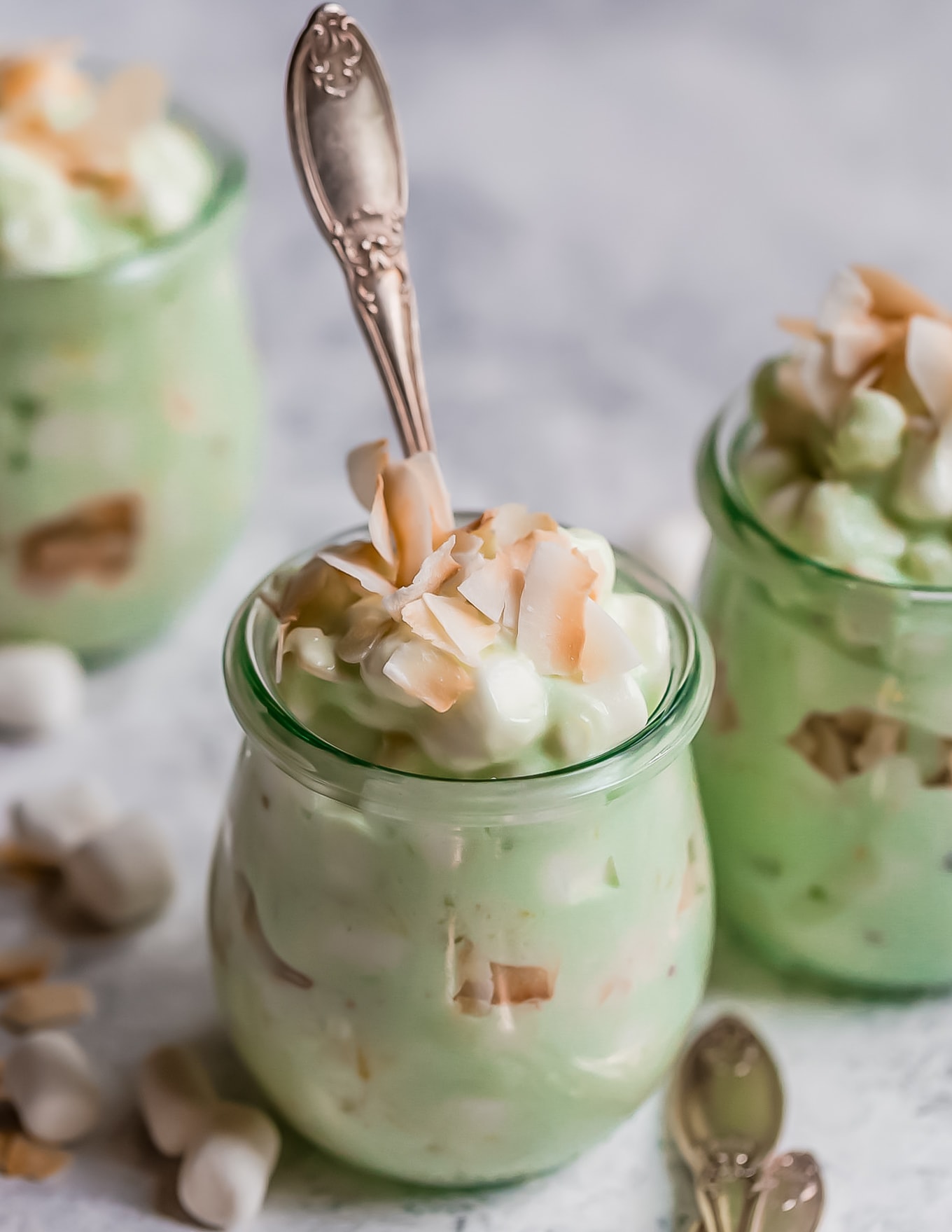 small jars of watergate salad with a spoon in it
