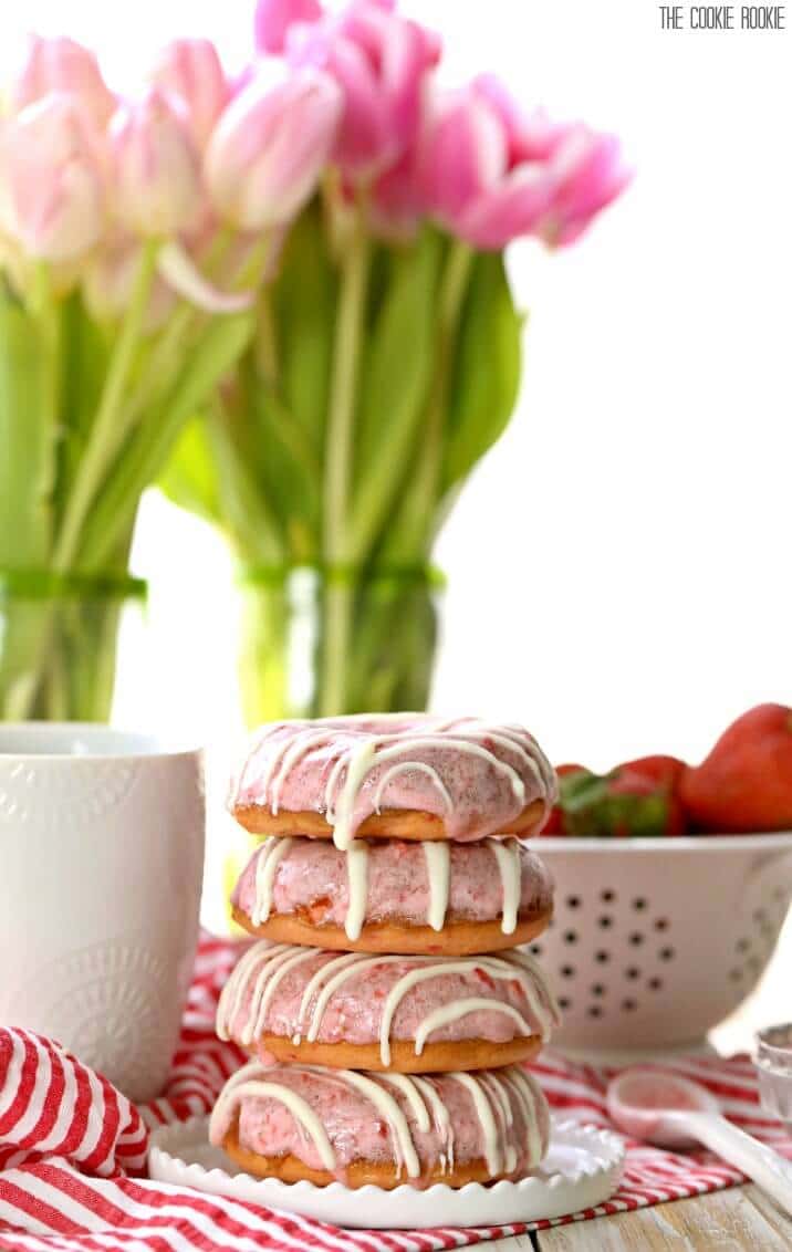 stacked donuts in front of vases of tulips