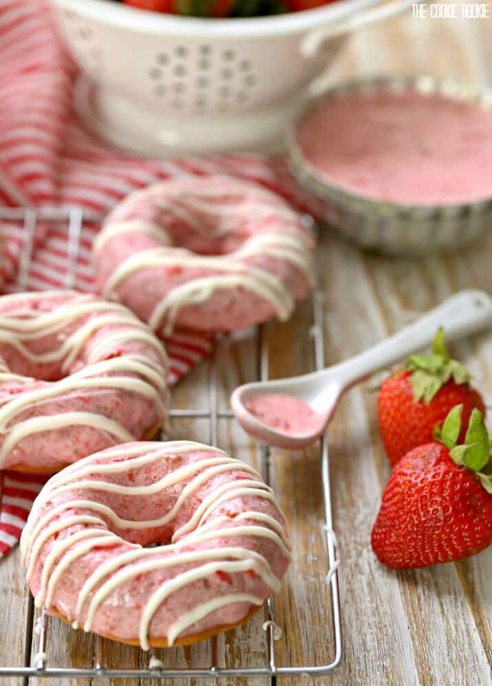 donuts on a wire rack with a bowl of frosting