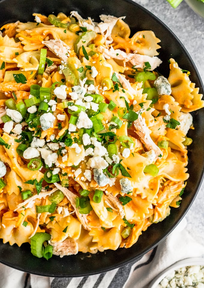 overhead shot of buffalo chicken pasta salad with green onions and blue cheese