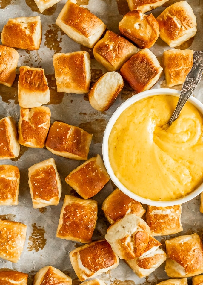 pretzel bites on a cookie sheet with cheese dip