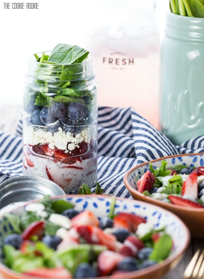 Salad in bowls in front of mason jars with salad inside