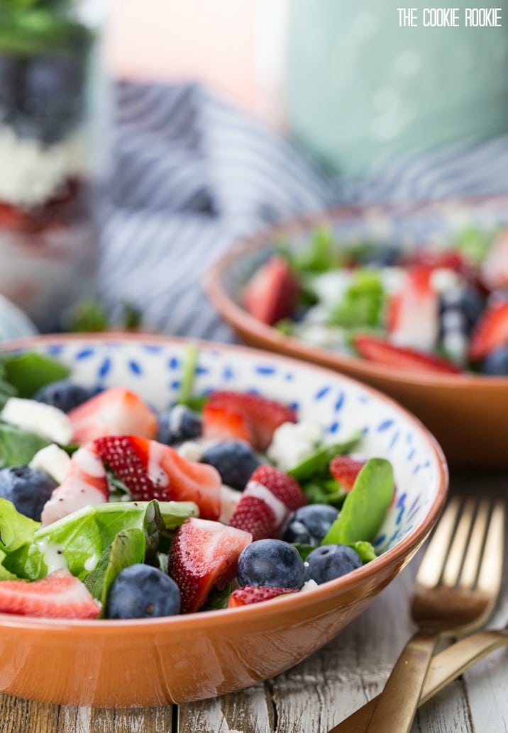 side view of salad in bowl with strawberries, blue berries, feta, and spinach