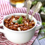 red beans in a white bowl on a red and white striped tablecloth.