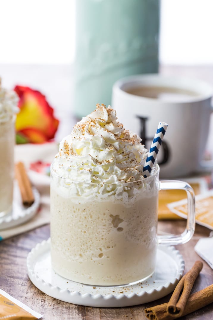 chai tea latte with a lot of whipped cream in a glass mug