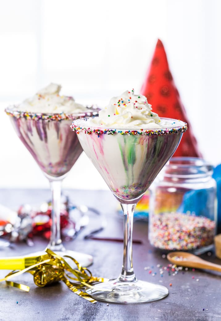 birthday cake martinis on a table with decorations.