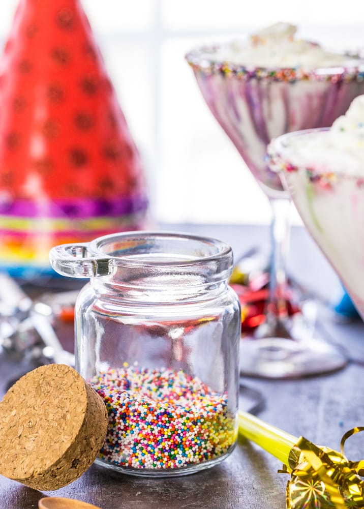 Jar of sprinkles in front of party hats