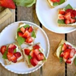 a plate with strawberries and basil on it.