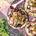 Spicy BBQ Chicken Tostadas, the perfect EASY Summer meal on the grill or inside in the broiler. Black beans, chicken, jalapeños, cilantro, cheese, and of course BBQ sauce! Adults and children ALL LOVE THESE!