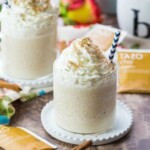 chai tea milkshake in glass on saucer with straw