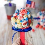 a person holding up a patriotic popcorn pop.
