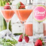 two martini glasses with strawberries and mint.