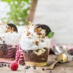 chocolate oreo pie cups with whipped cream and raspberries.