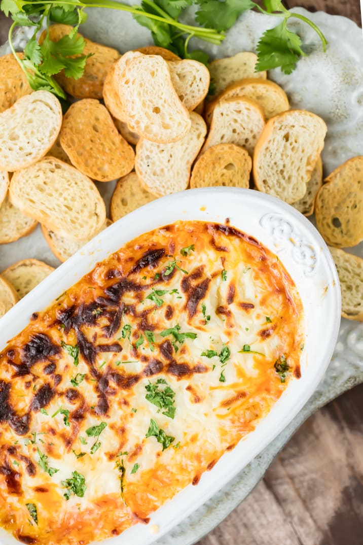 crock pot queso fundido surrounded by toasted bread