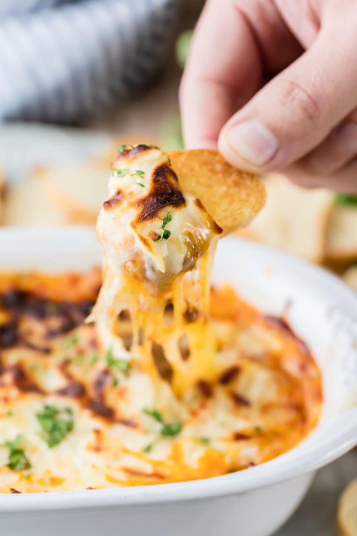 dipping bread into queso with chorizo