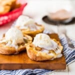 apple pie taco boats topped with ice cream on a wooden board