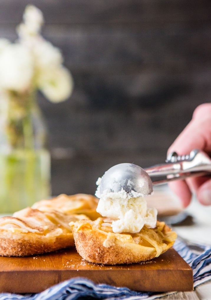 ice cream being added to mini apple pie taco boats