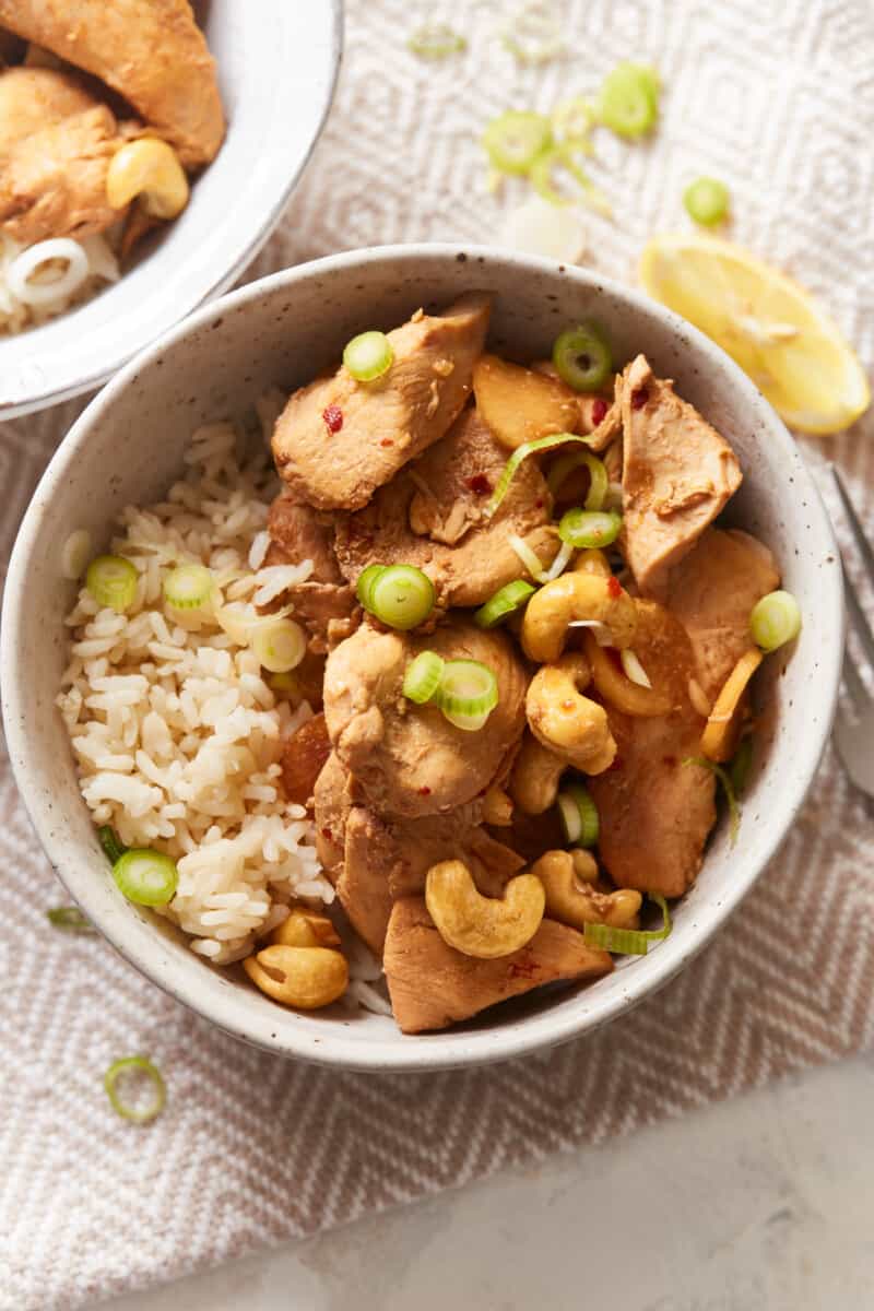 overhead view of crockpot cashew chicken in a tan bowl with rice.