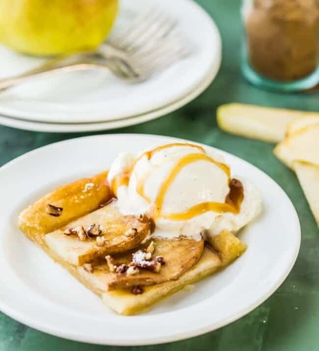 pear tart slice on a plate with vanilla ice cream